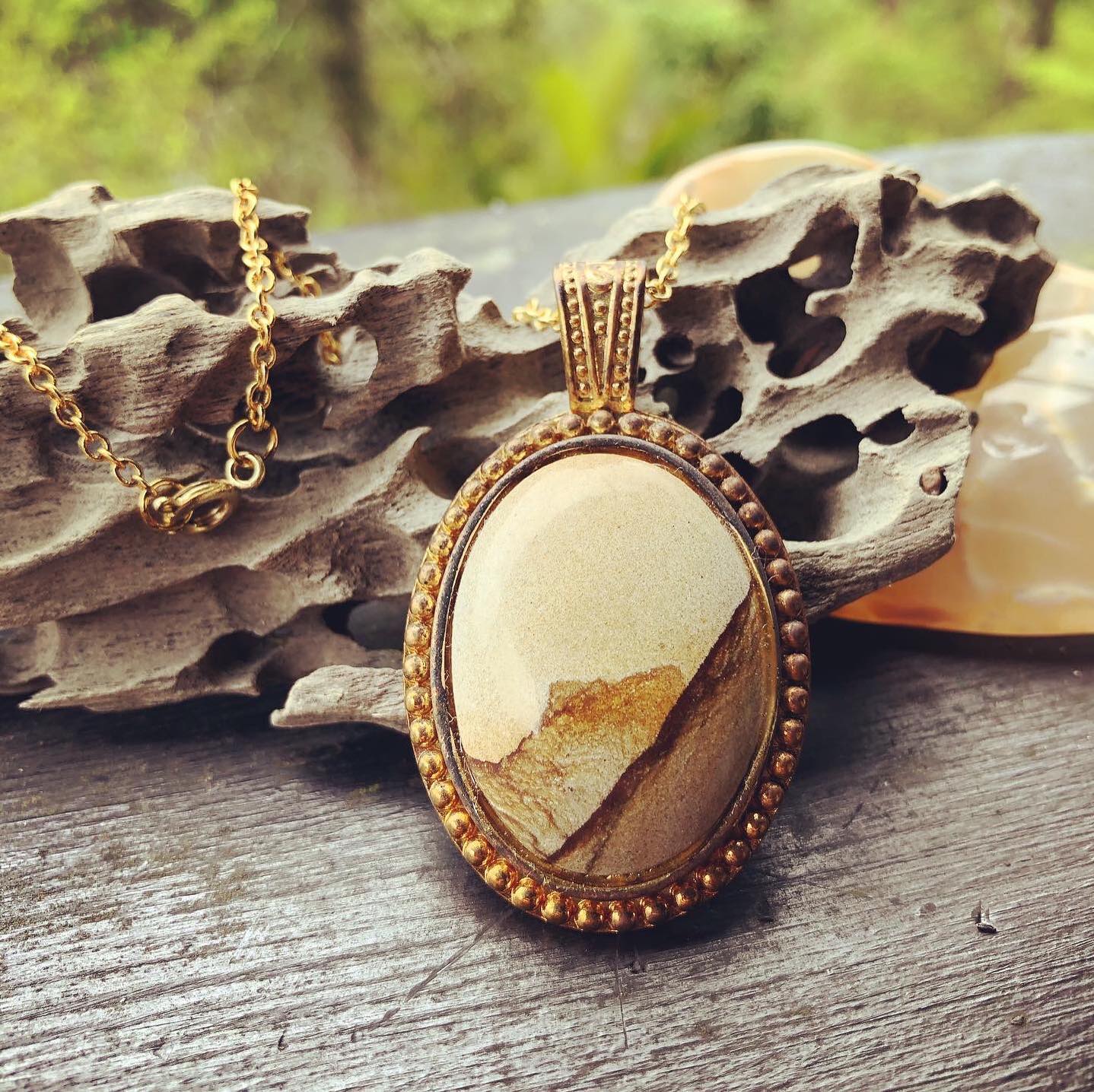 Necklace with a natural Kalahari Desert landscape jasper with a beautiful mountain scenek, naturally created in tan and brown, hand polished to a 30x22mm cabochon and set in a gold plated setting with 19 inch chain, front