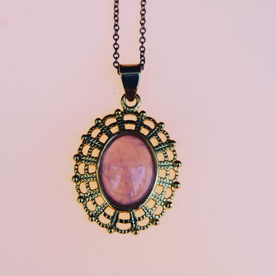 Necklace with glowing pink Rose Quartz, hand polished to an 18x13mm oval cabochon and set in a gold plated setting with 19 inch chain.