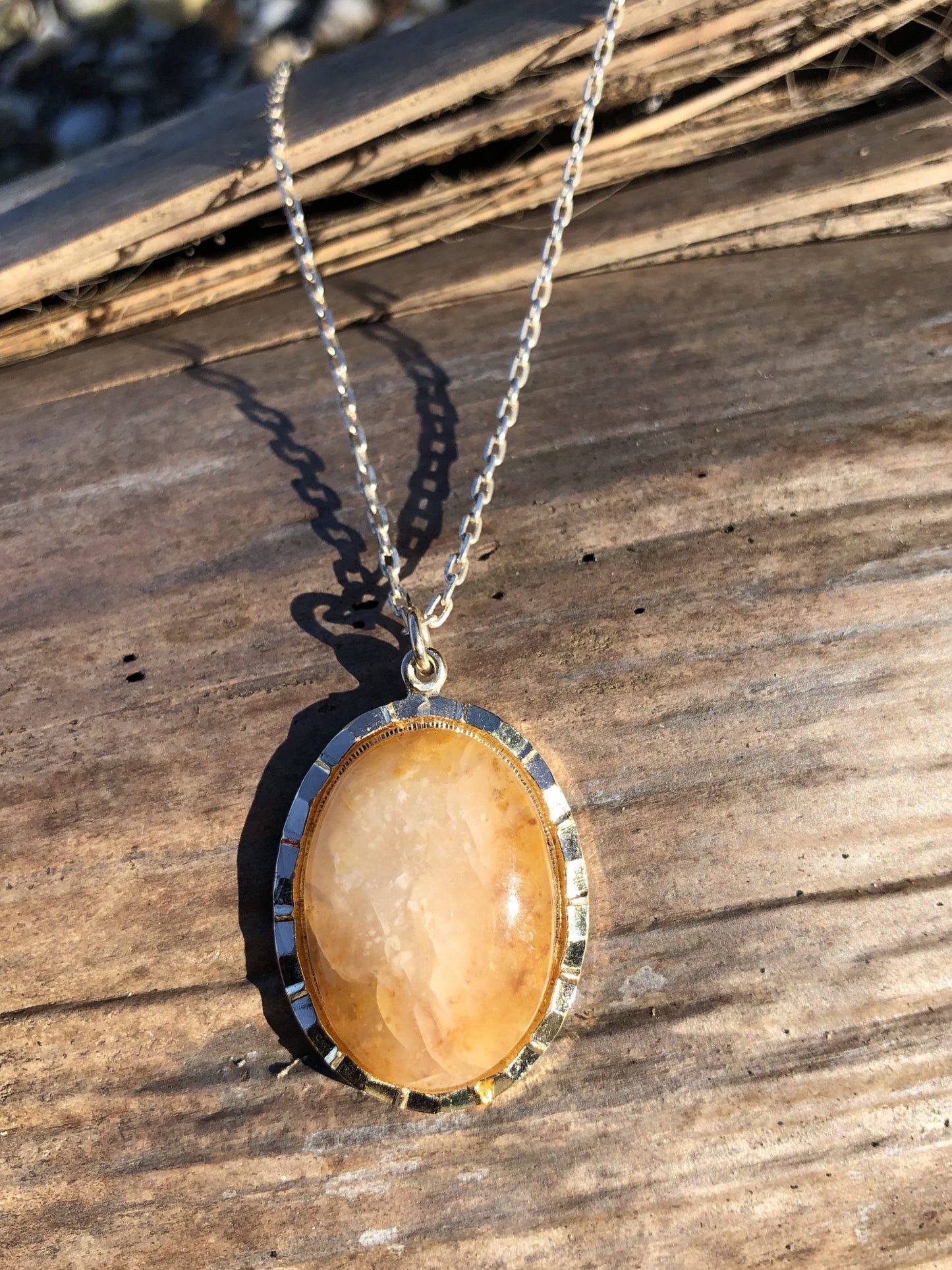 Necklace with a beautiful honey chert from Coromandel New Zealand with swirls of yellow and white. This stone is hand polished in a 25x18mm cabochon and set in a silver plated setting with a 19 inch chain on wood