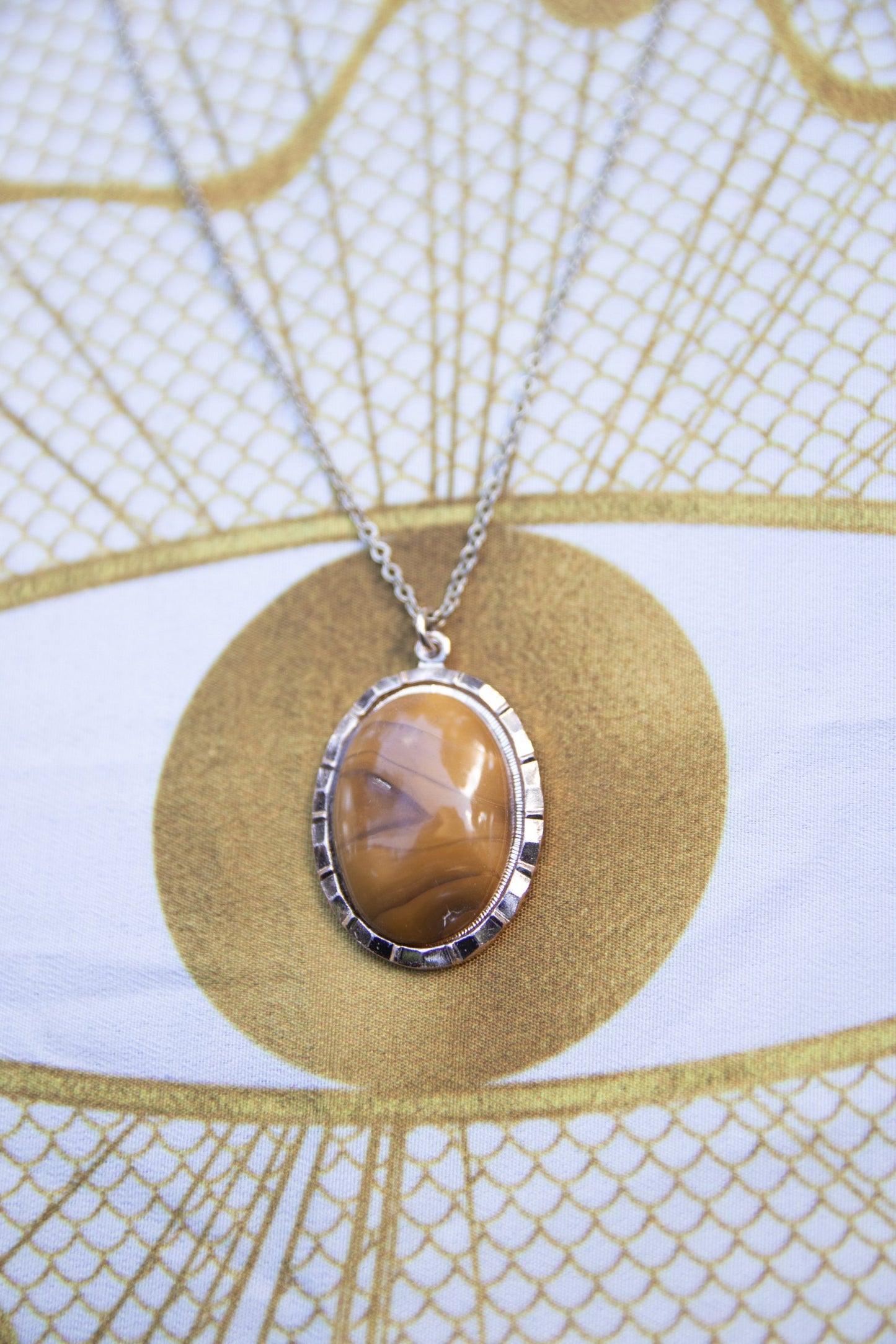 Necklace with natural New Zealand Carnelian, with rich orange showing through swirling browns, hand polished to a 25x18mm oval cabochon and set in a silver plated setting with 19 inch chain, closer