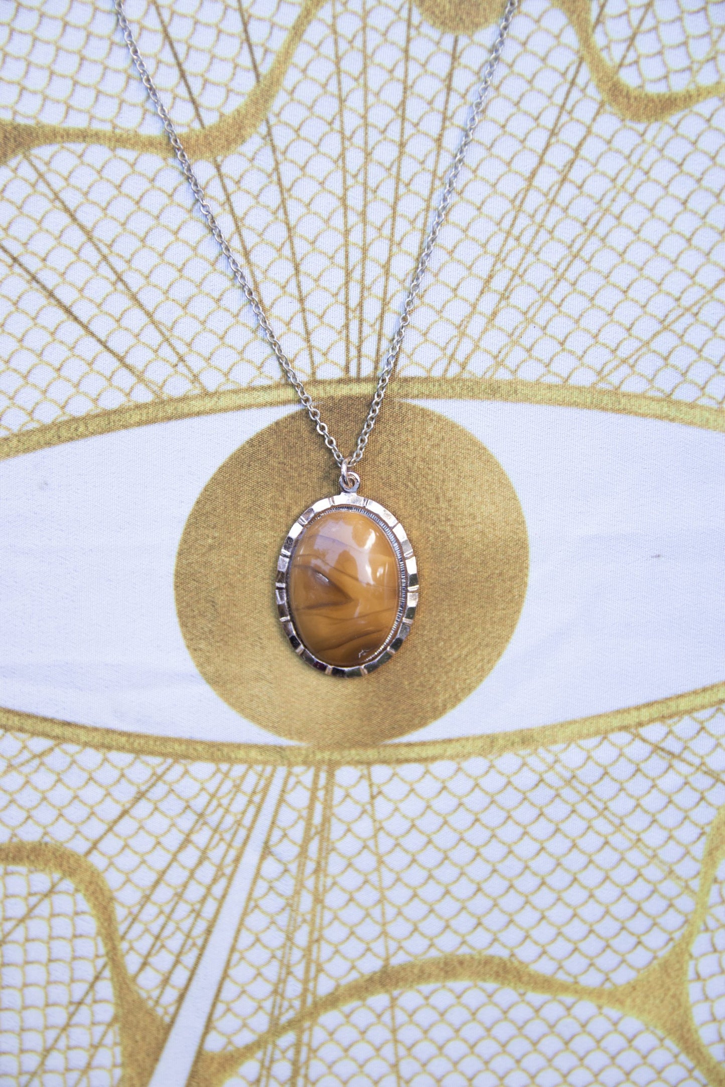 Necklace with natural New Zealand Carnelian, with rich orange showing through swirling browns, hand polished to a 25x18mm oval cabochon and set in a silver plated setting with 19 inch chain, farther