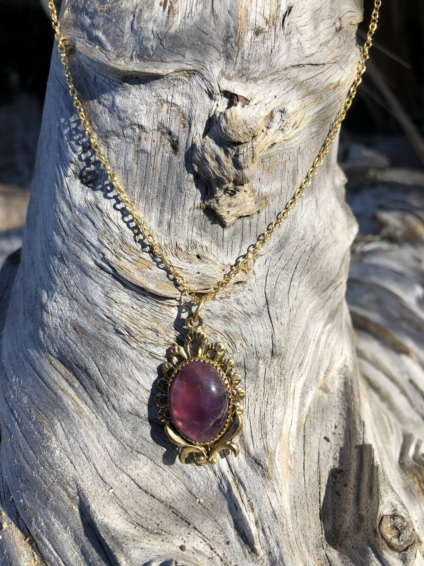 Necklace with rich, dark purple Amethyst, hand polished to a 16x12mm oval cabochon and set in a gold plated setting with 19 inch chain on driftwood