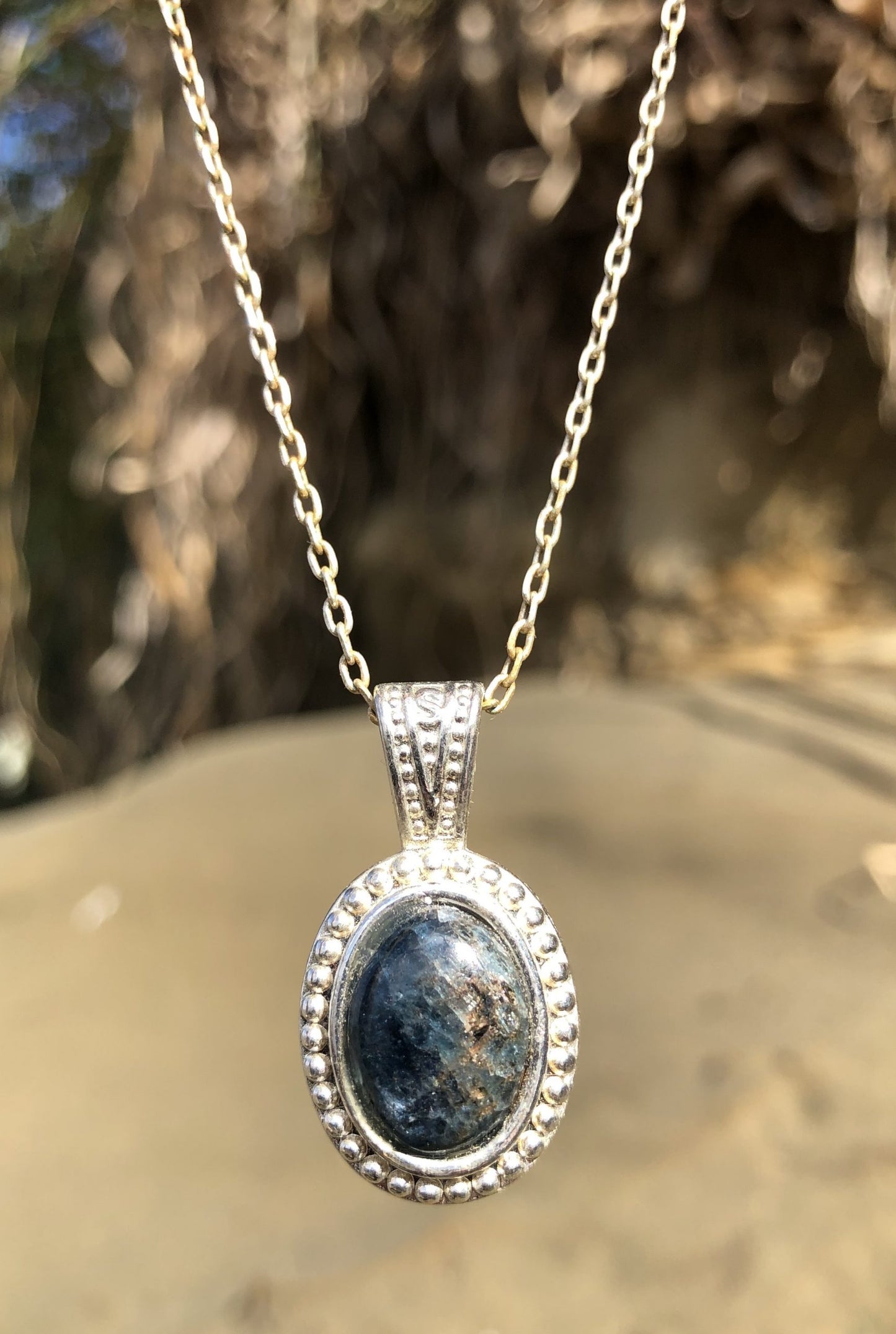 Necklace with glistening blue iolite, hand polished to a 14x12mm cabochon and set in a silver-plated setting with 19 inch chain, front