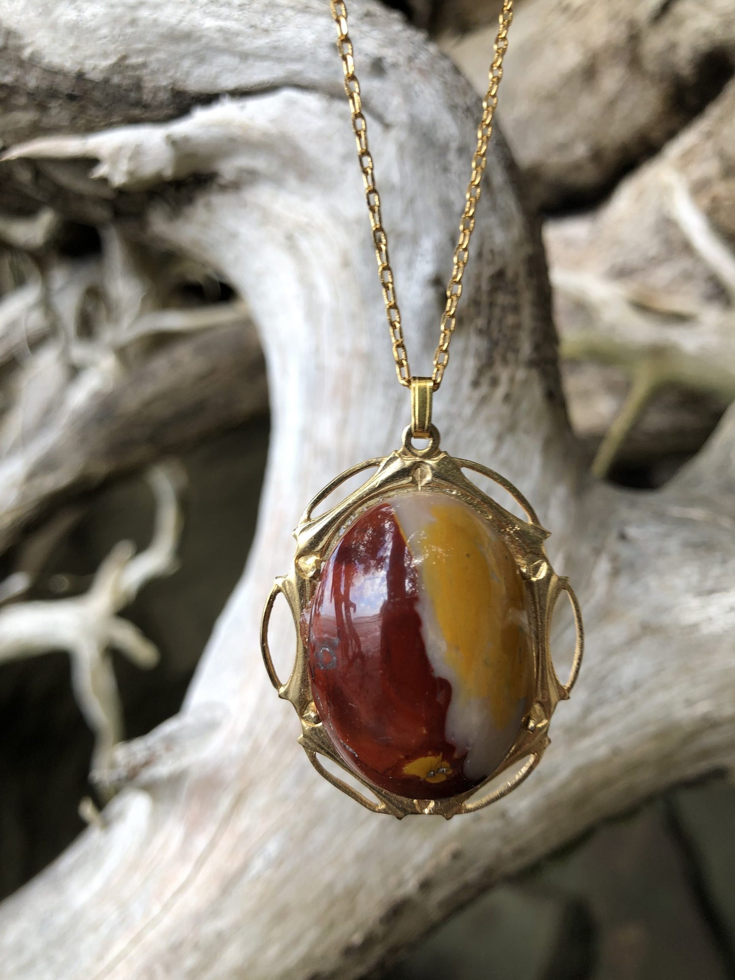 Necklace of Mookaite from Western Australia. This stone includes all 3 classic colors of Mookaite, red, yellow, and white. I hand polished this stone to a 30x22mm cabochon, set in gold-plated setting with 19 inch chain on driftwood