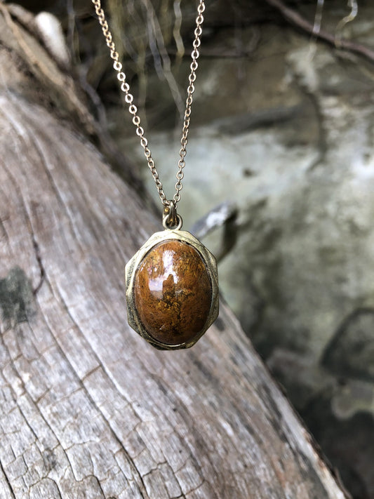 Necklace with New Zealand natural Chakra Jasper, luscious red with patterns of every color of the chakras, yellow, blue, black, orange, white patterns throughout, hand polished to a 25x18mm cabochon and set in a gold-plated setting with 19 inch chain on log