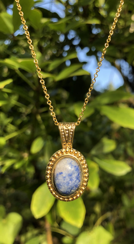 Necklace of natural blue quartz from Brazil, hand polished to a 14x10mm cabochon and set in a gold-plated setting with 19 inch chain.