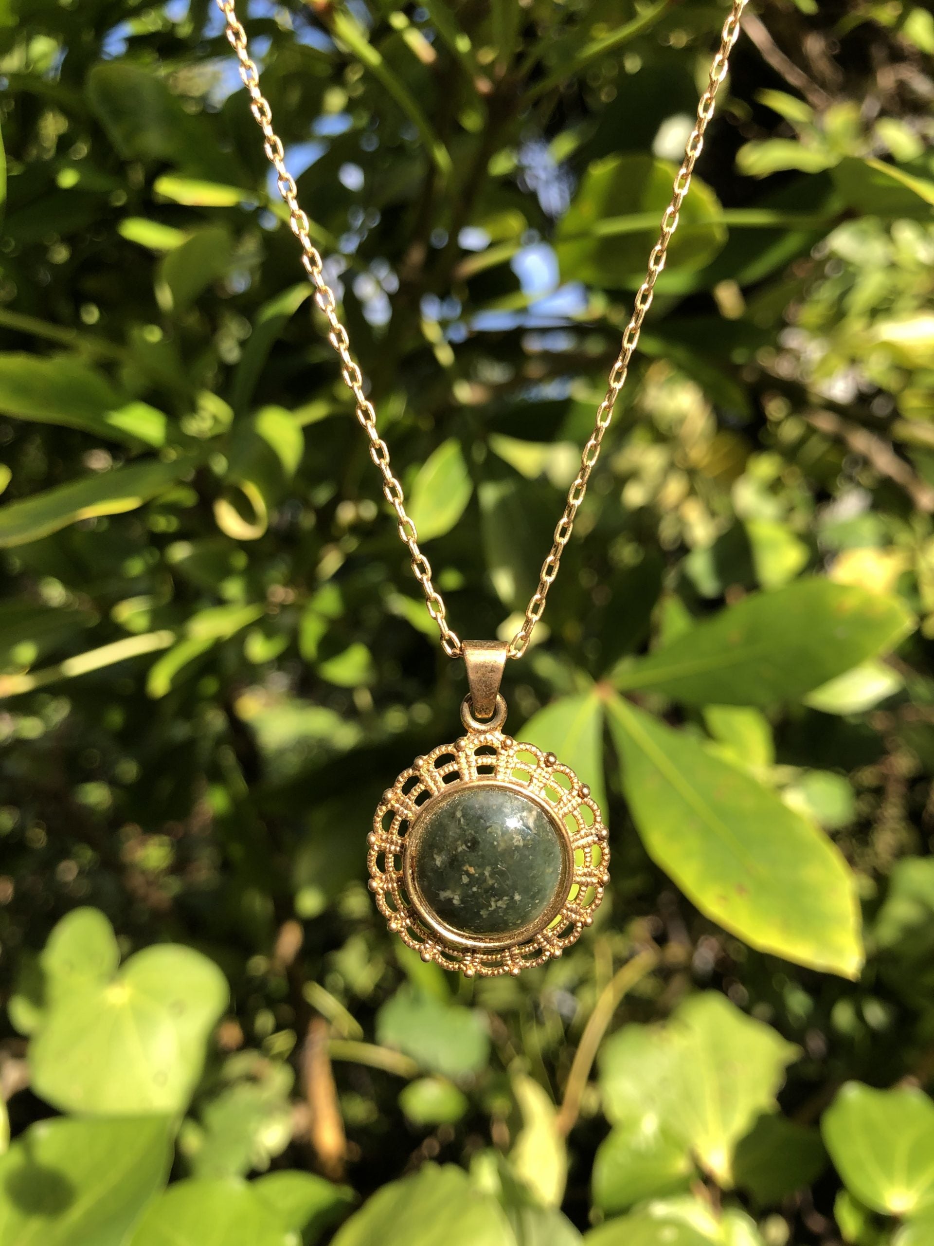 Necklace with natural Australian Nephrite Jade,&nbsp; green with subtle markings, hand polished to a 14mm round cabochon and set in a gold-plated setting with 19 inch chain.